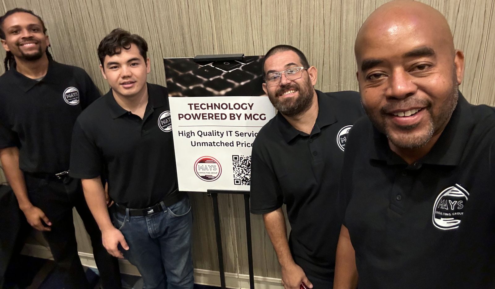 Four members of the MCG team in black MCG polos at a client event