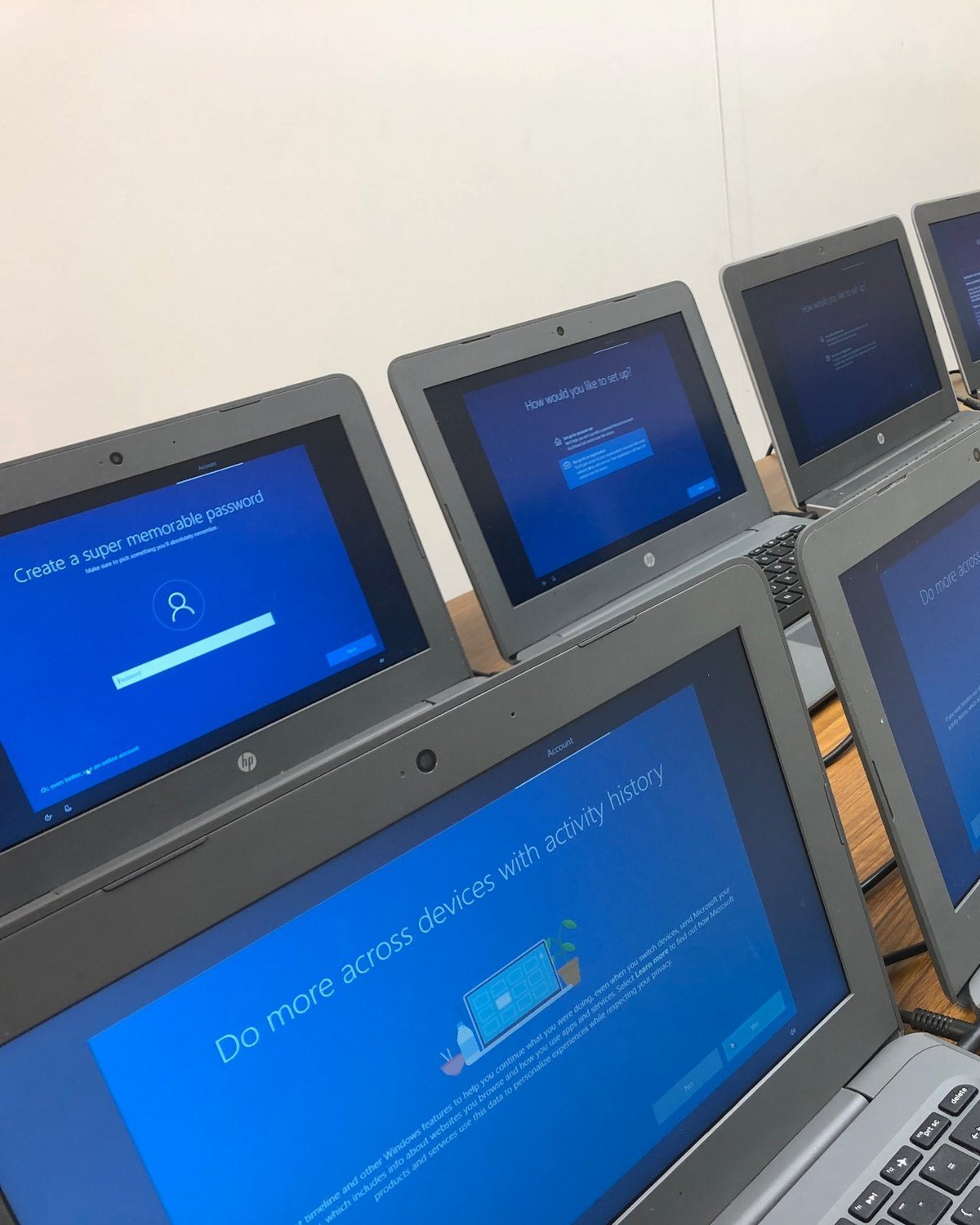 An MCG technician setting up a row of student laptops